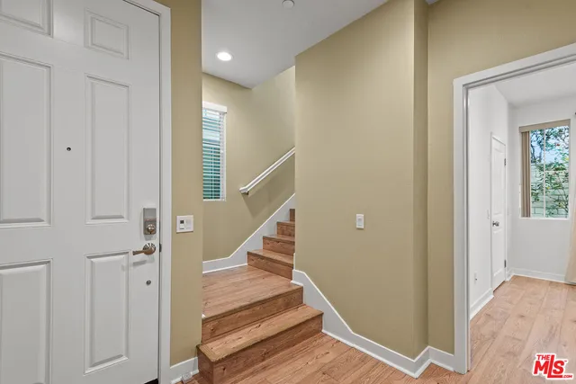 a view of entryway with wooden floor and stairs