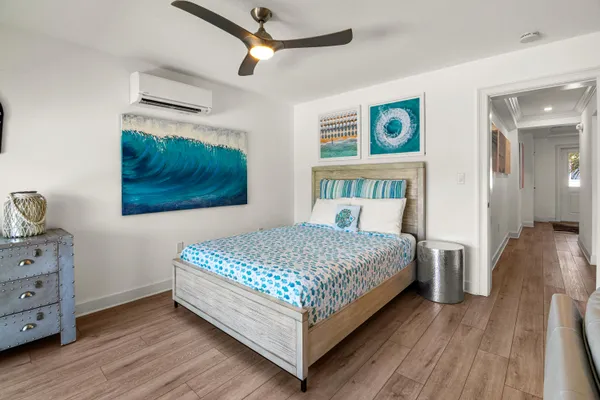 a kitchen with stainless steel appliances a stove a sink a refrigerator white cabinets and wooden floor