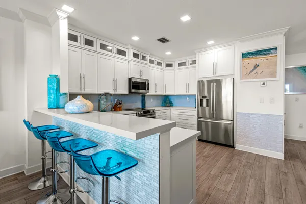 a kitchen with stainless steel appliances kitchen island granite countertop a sink and a living room view
