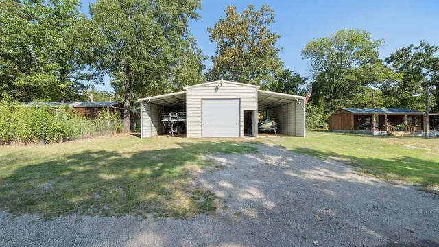 a view of a house with a yard and large tree