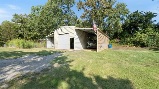 a view of a house with a yard and large trees