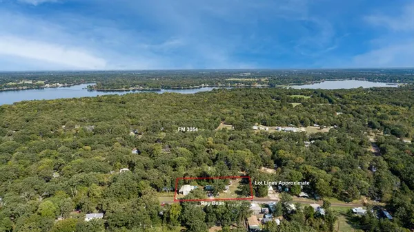 an aerial view of residential houses with outdoor space and trees