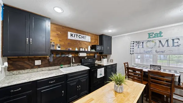 a kitchen with stainless steel appliances kitchen island granite countertop a sink and cabinets