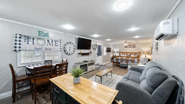 a living room with furniture a flat screen tv and kitchen view