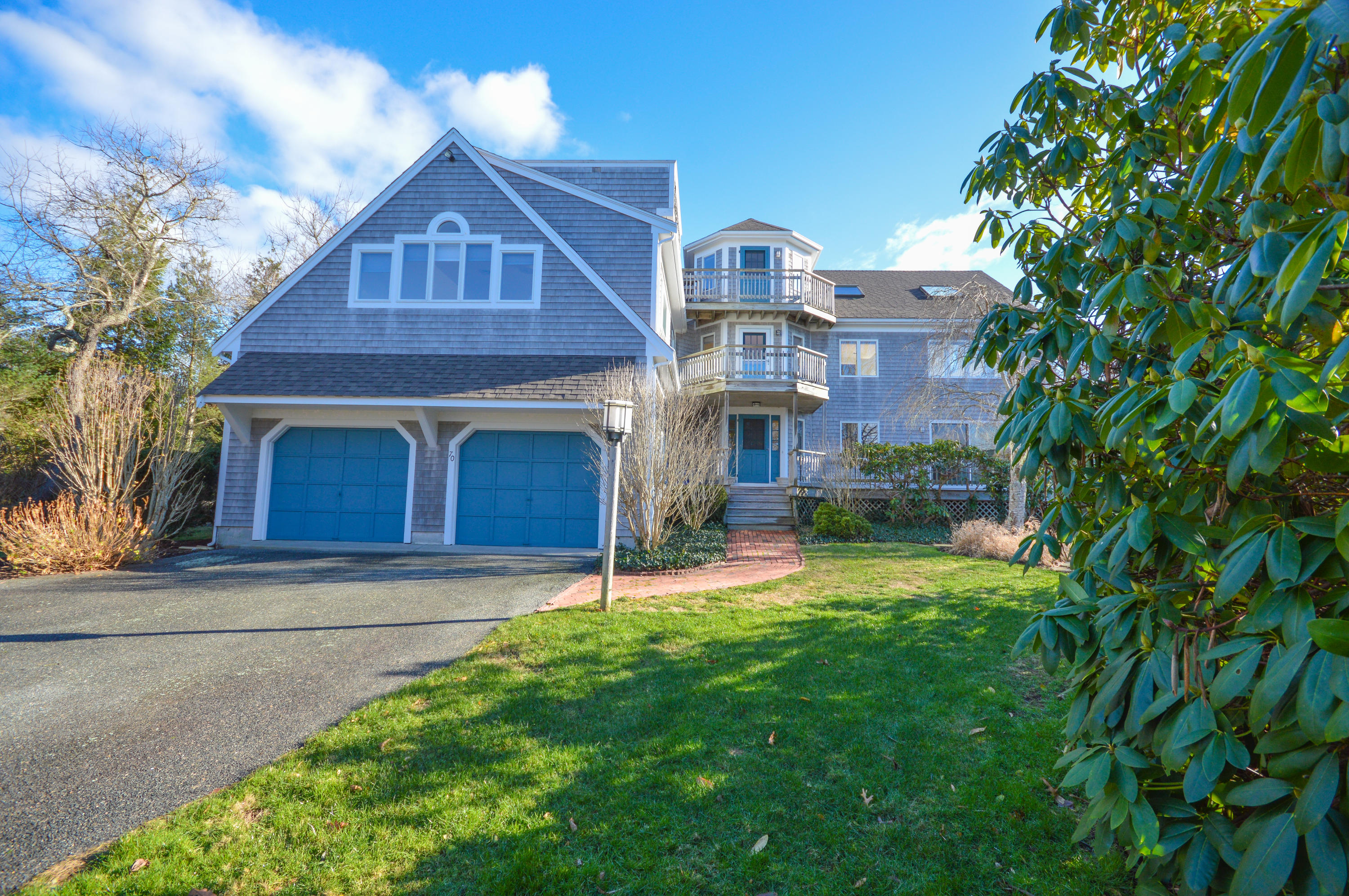 a view of a yard in front of a house with plants and large tree
