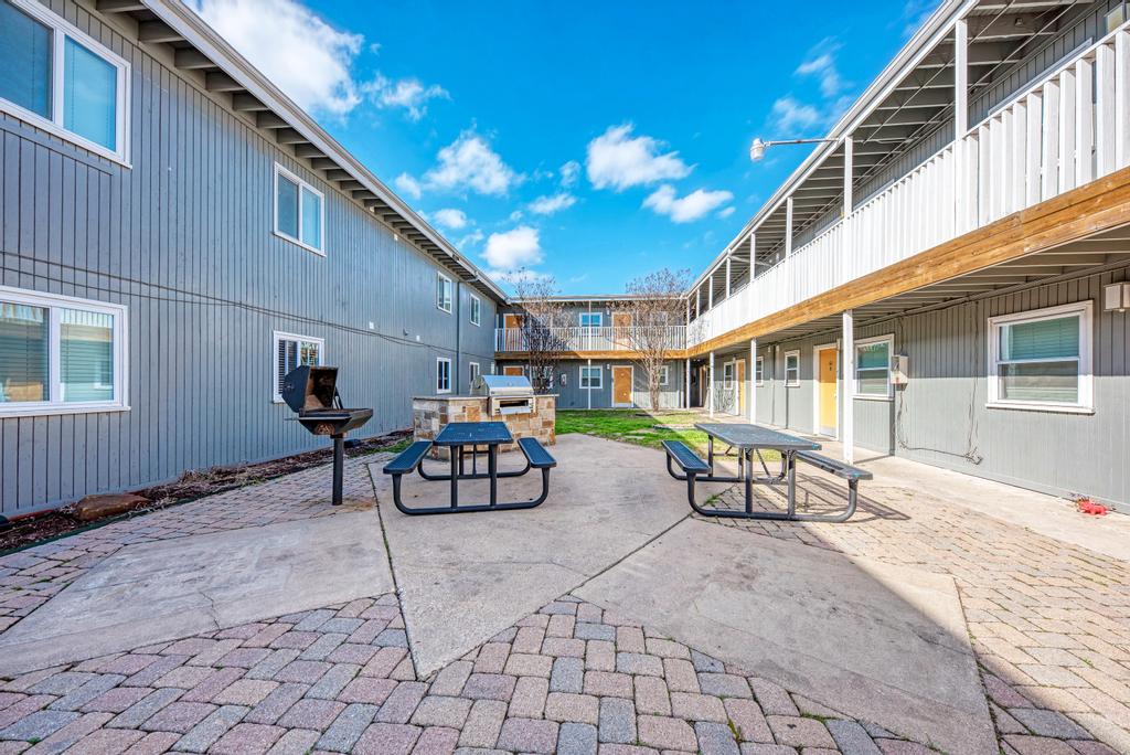 2401 Manor St Road, Unit 118 Austin, TX 78722 - Photo 5 of 17 a view of a patio with table and chairs and potted plants