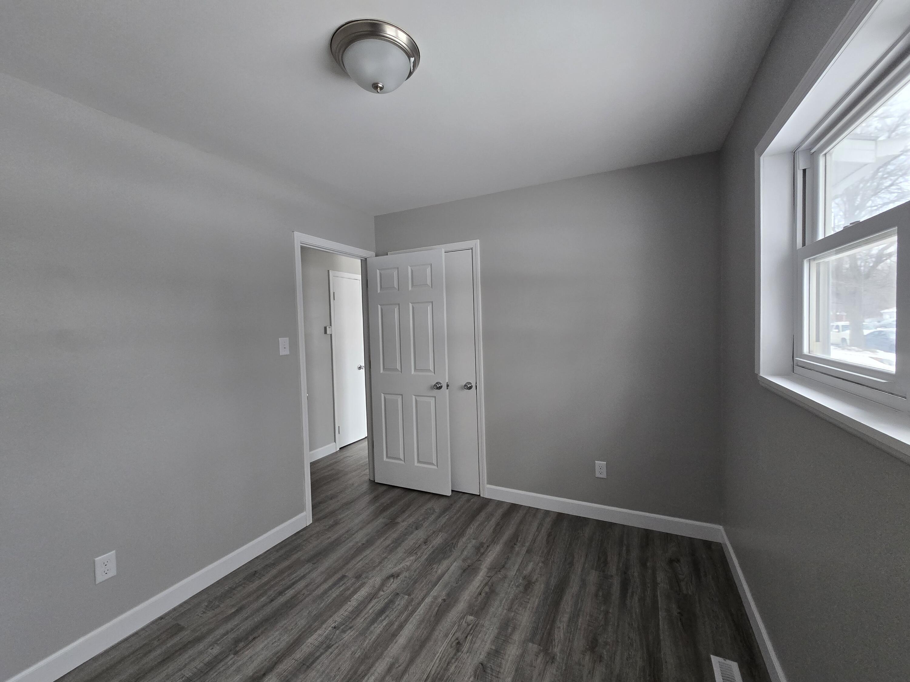 1044 Hobart Street Gary, IN 46406 - Photo 13 of 22 an empty room with wooden floor and windows