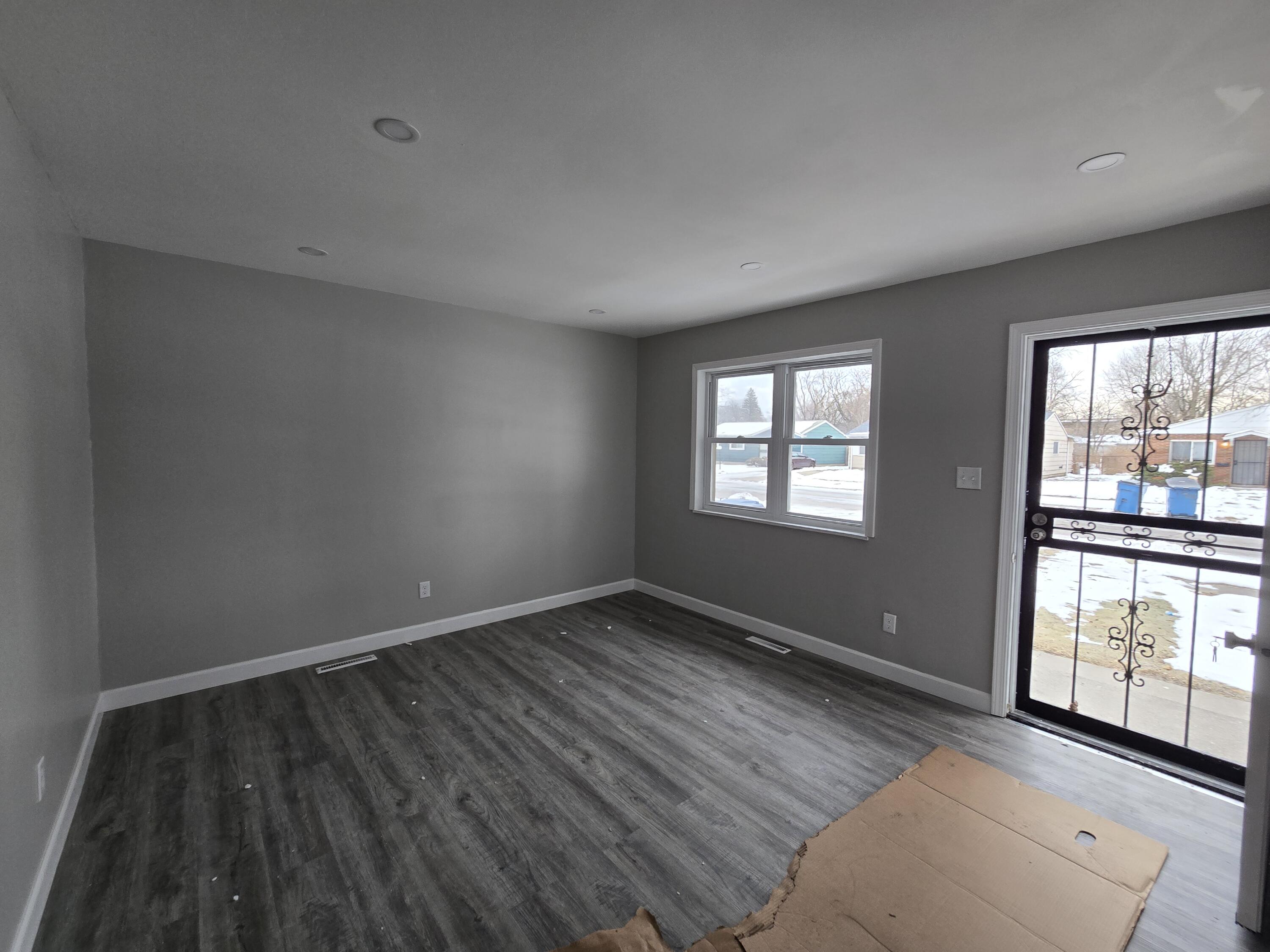1044 Hobart Street Gary, IN 46406 - Photo 4 of 22 an empty room with wooden floor and windows