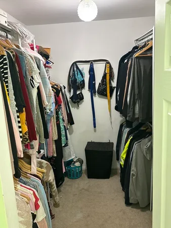 a view of walk in closet with clothes and shoes