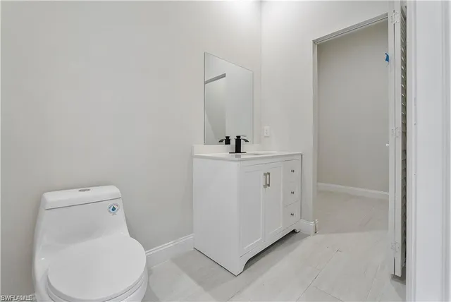 a white toilet sitting next to a bathroom sink