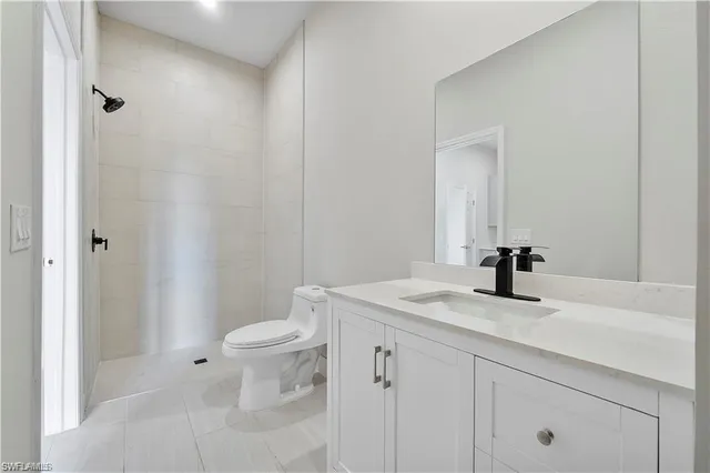 a bathroom with a granite countertop sink a toilet and a mirror
