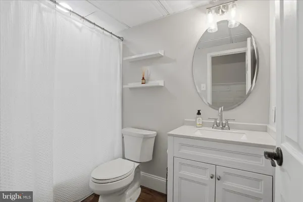 a bathroom with a toilet a sink and mirror