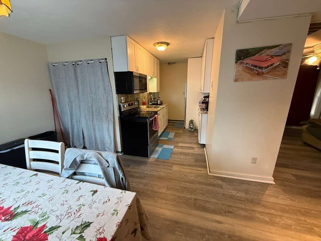 98 School Street Lowell, MA 01854 - Photo 11 of 40 a bedroom with a bed and a television