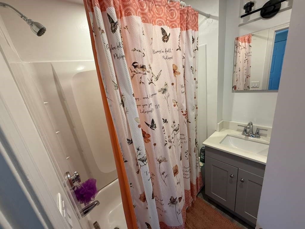 98 School Street Lowell, MA 01854 - Photo 27 of 40 a bathroom with a sink and a shower curtain