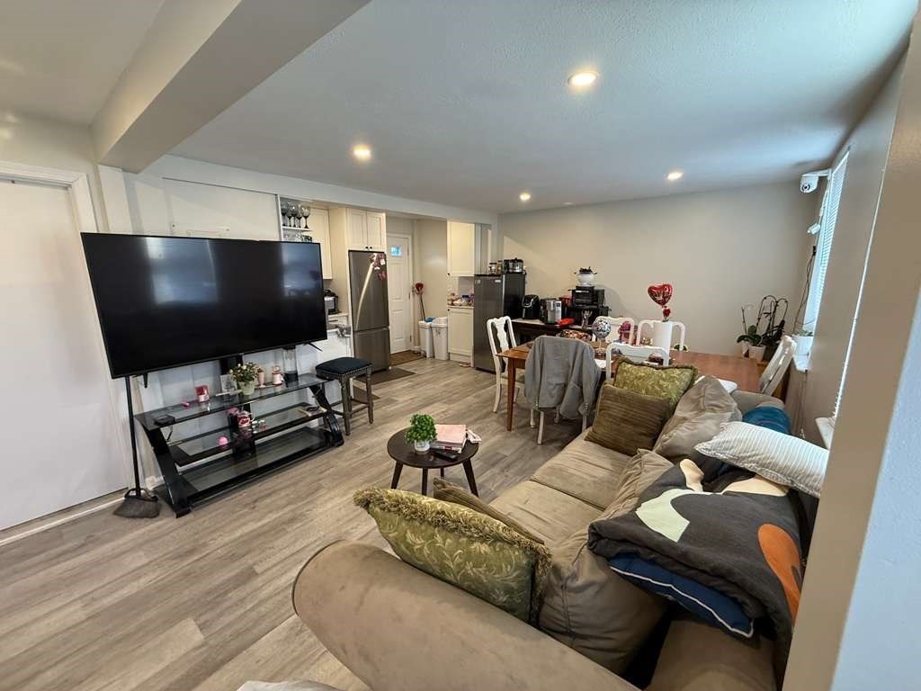 98 School Street Lowell, MA 01854 - Photo 29 of 40 a living room with furniture and a flat screen tv