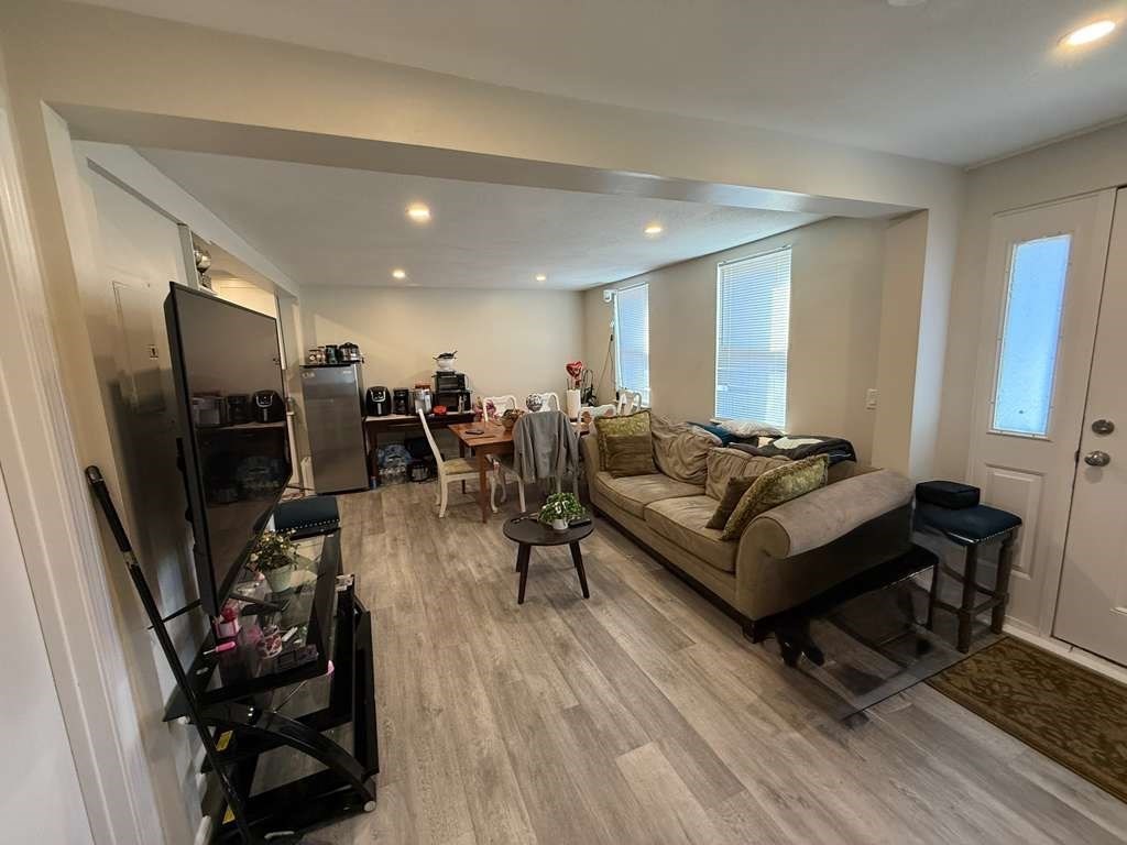 98 School Street Lowell, MA 01854 - Photo 34 of 40 a living room with furniture a flat screen tv and a refrigerator