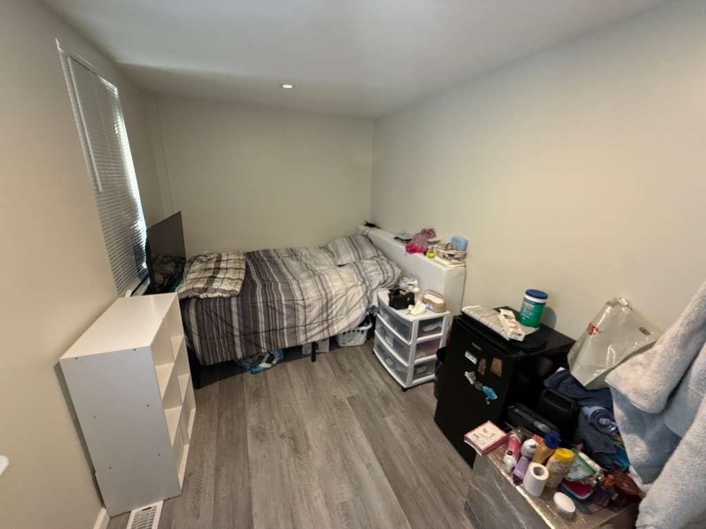 98 School Street Lowell, MA 01854 - Photo 36 of 40 a bedroom with a bed and wooden floor