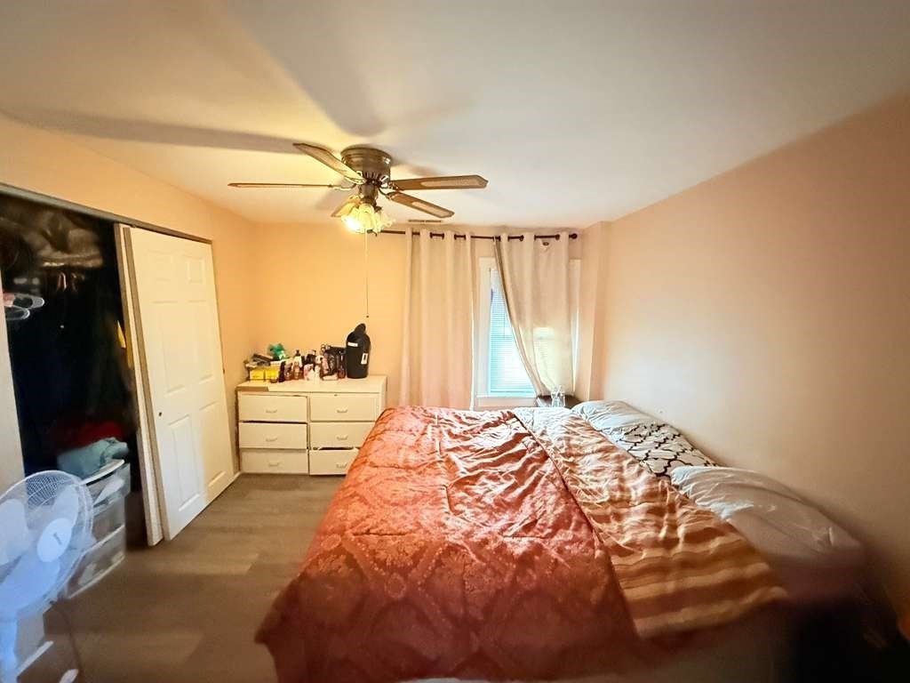 98 School Street Lowell, MA 01854 - Photo 6 of 40 a bedroom with a bed and a walk in closet