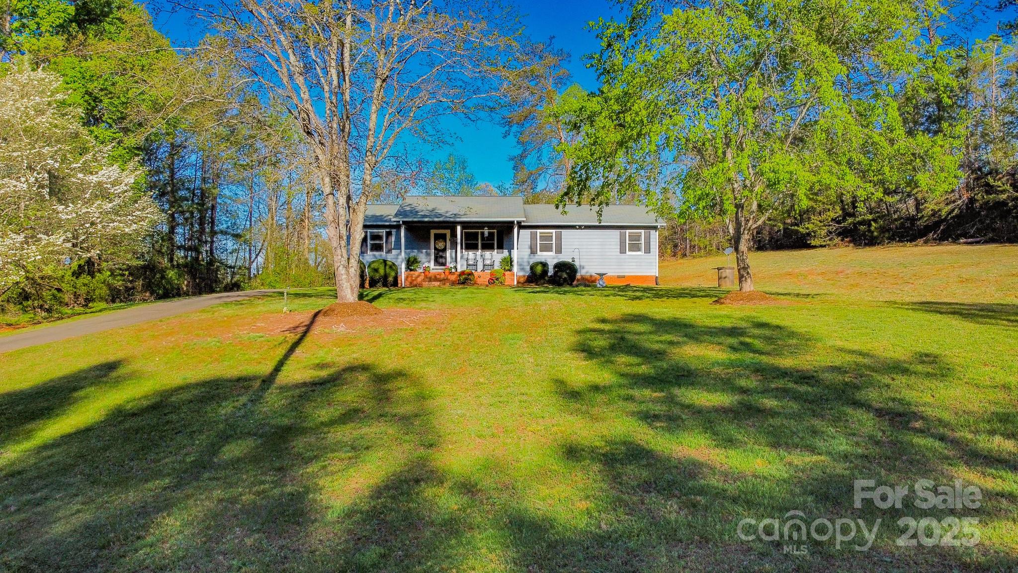 a view of a house with pool and a yard