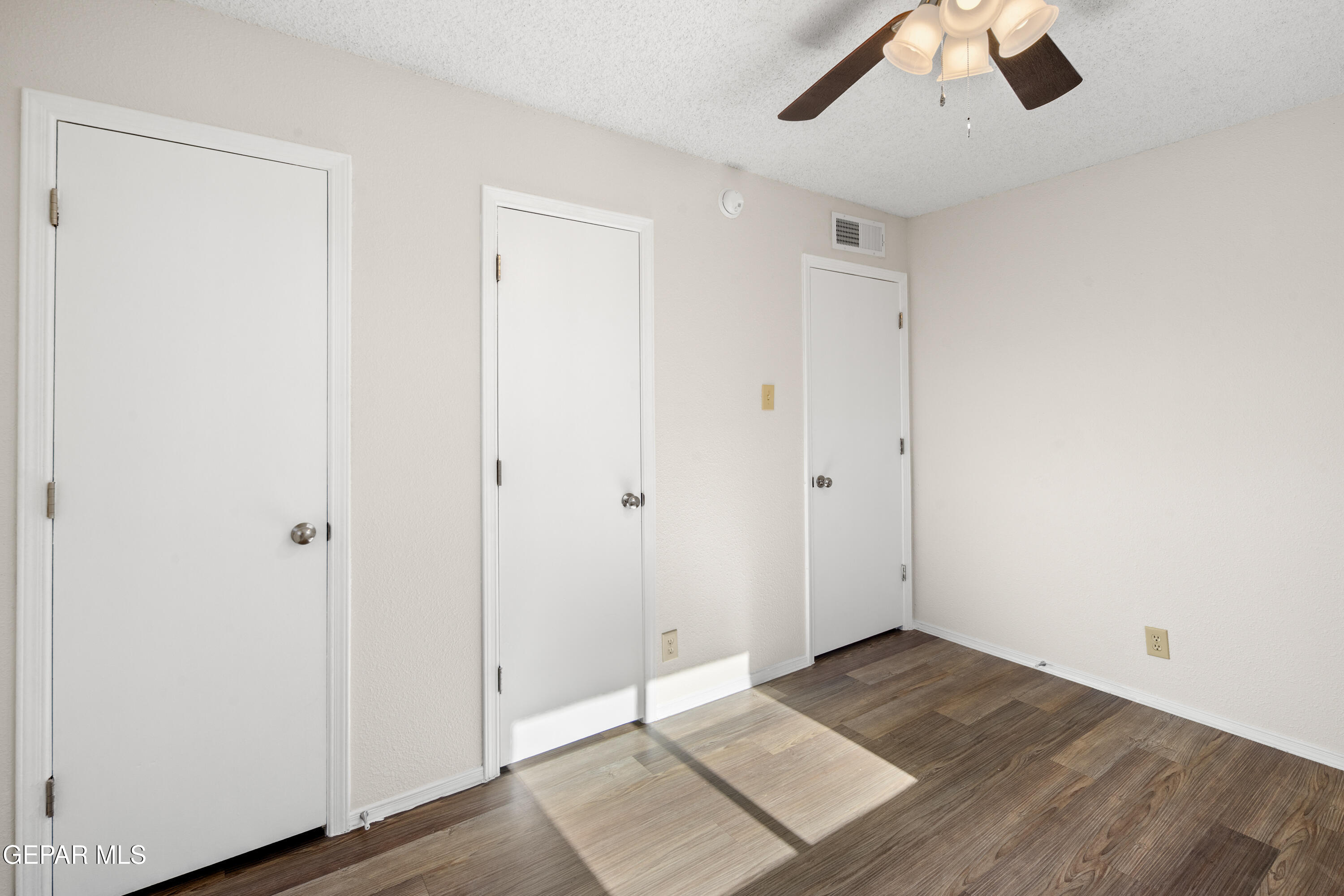 10341 Whyburn Street El Paso, TX 79924 - Photo 13 of 22 an empty room with wooden floor and ceiling fan