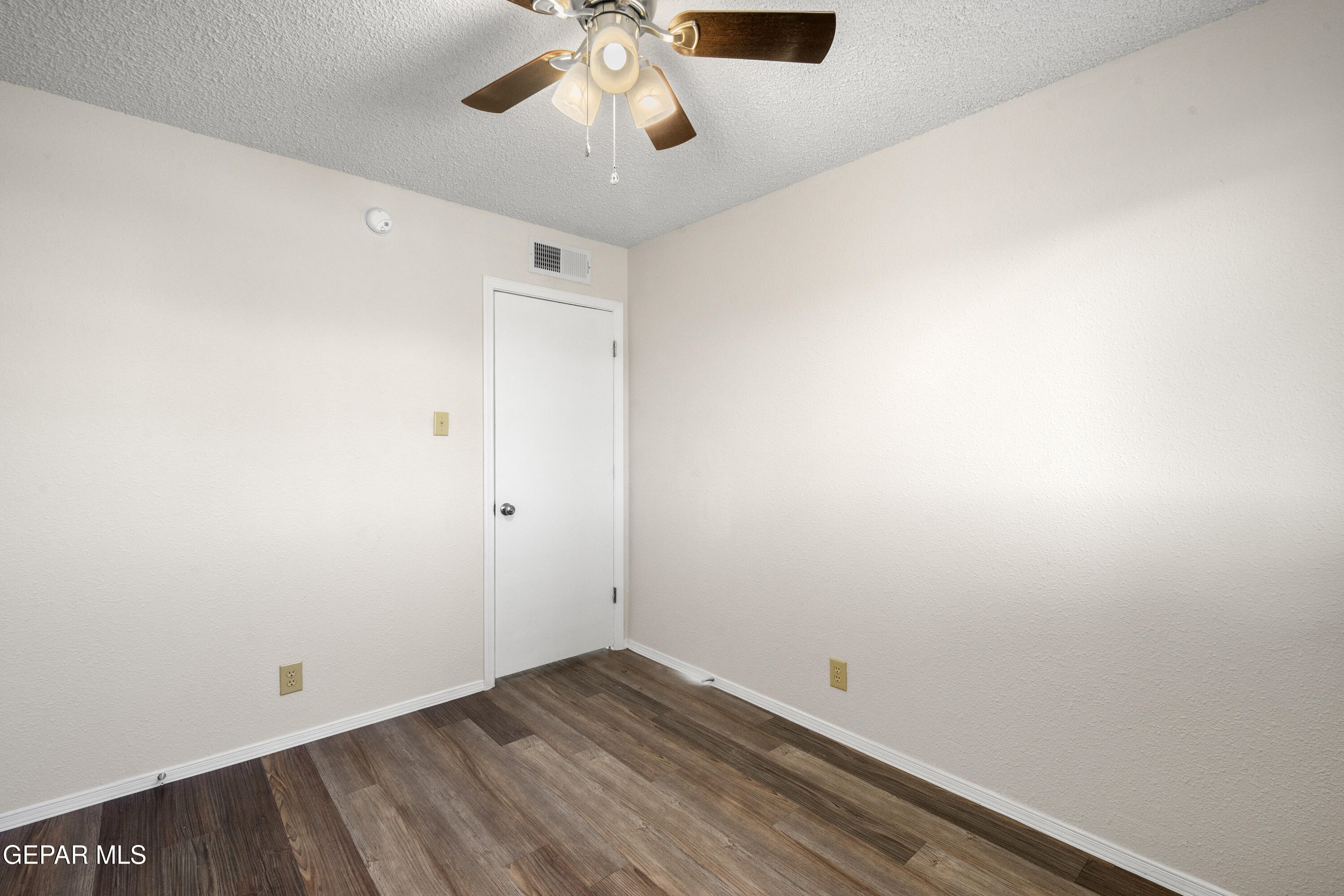 10341 Whyburn Street El Paso, TX 79924 - Photo 15 of 22 an empty room with a chandelier fan and wooden floor