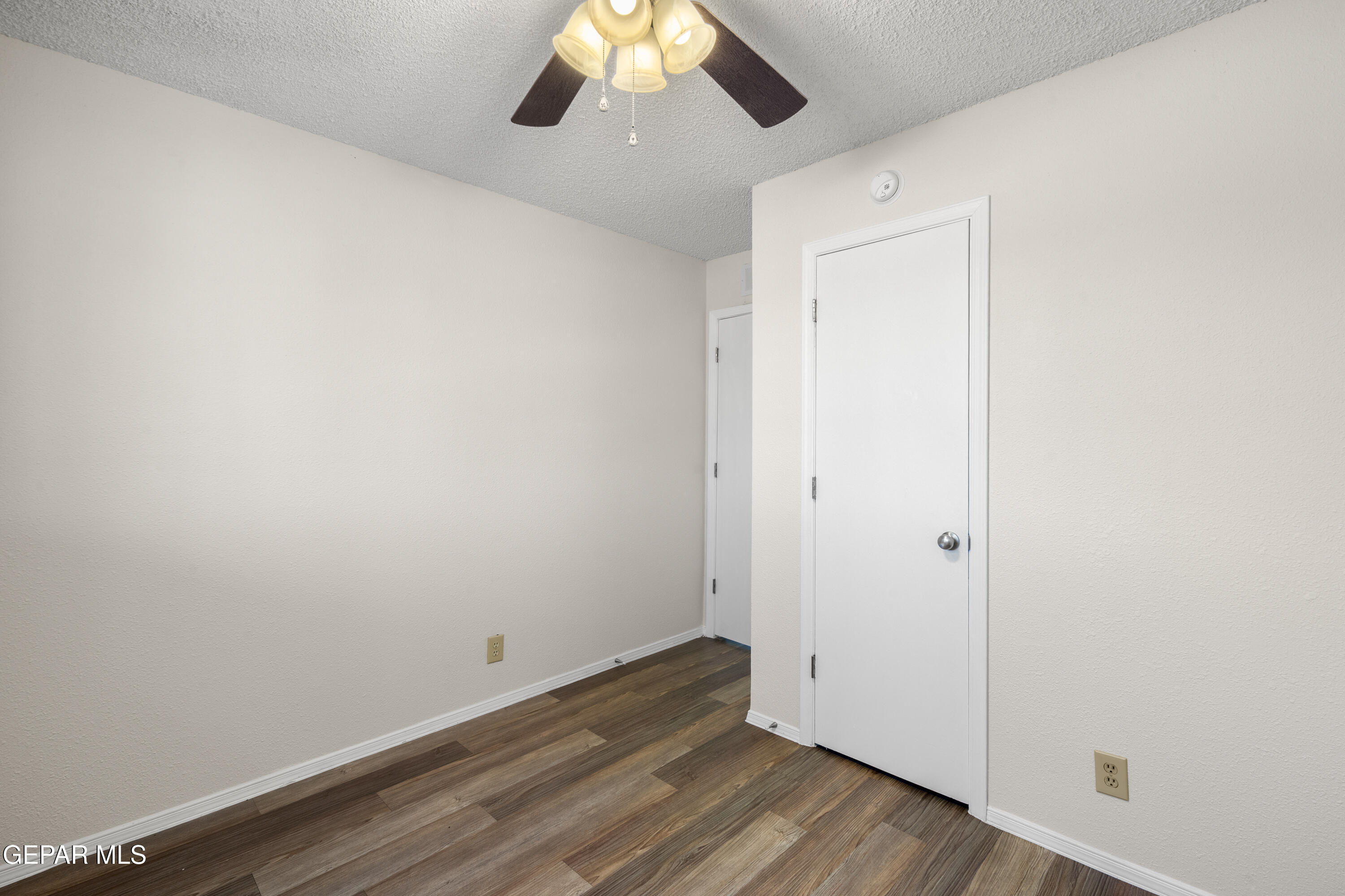 10341 Whyburn Street El Paso, TX 79924 - Photo 17 of 22 an empty room with wooden floor fan and windows