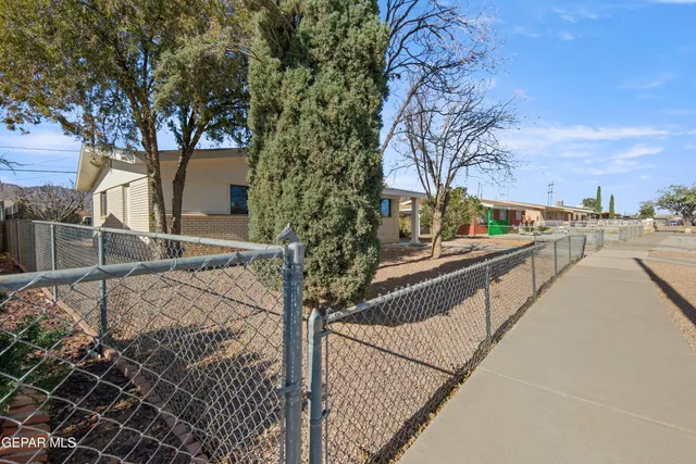 a view of a pathway with a wrought fence