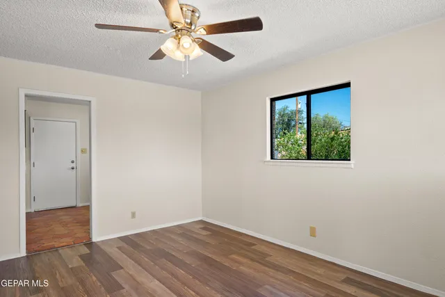 an empty room with a window and a ceiling fan