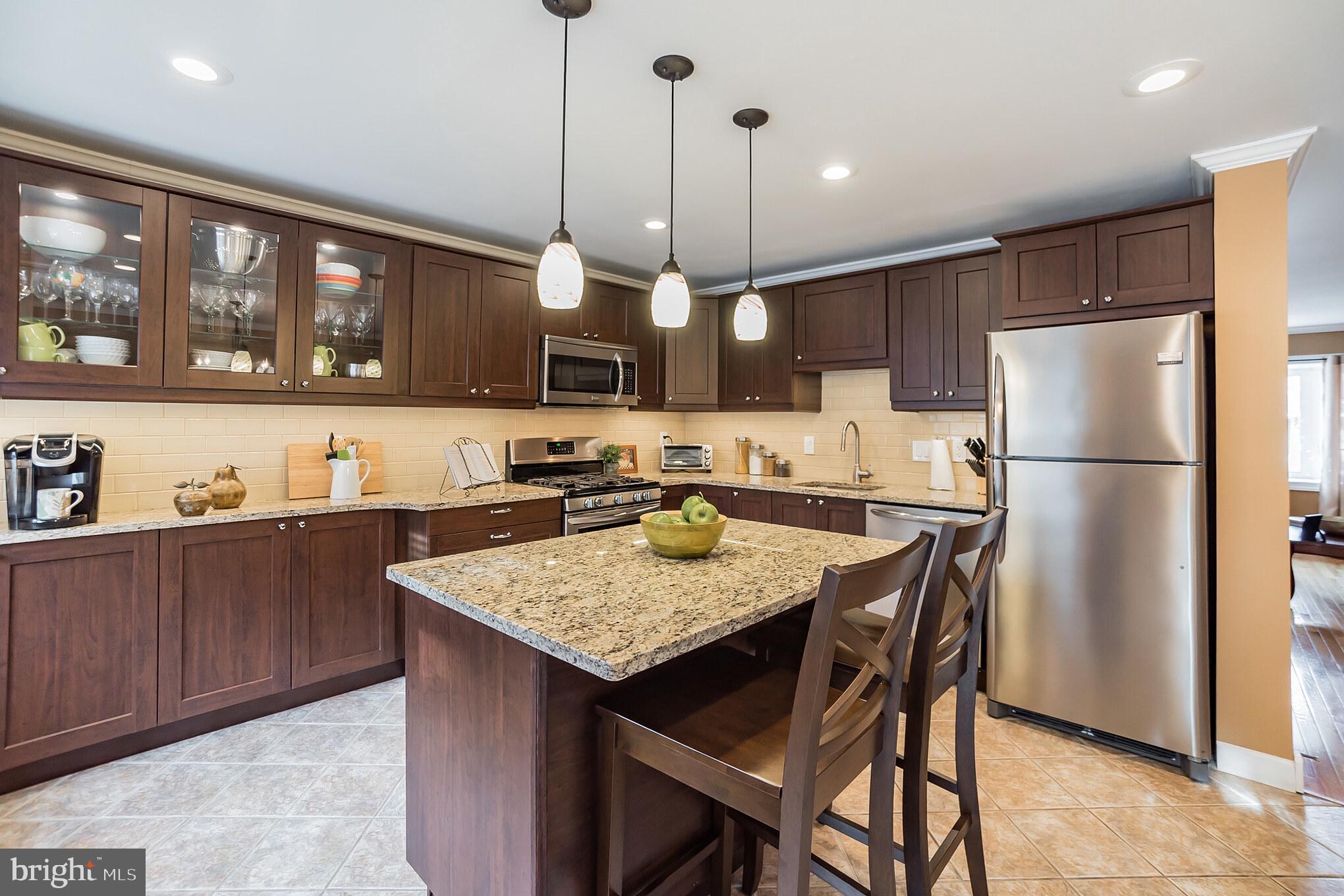 12817 Cabell Road Philadelphia, PA 19154 - Photo 11 of 30 a kitchen with a refrigerator a stove a sink and chairs