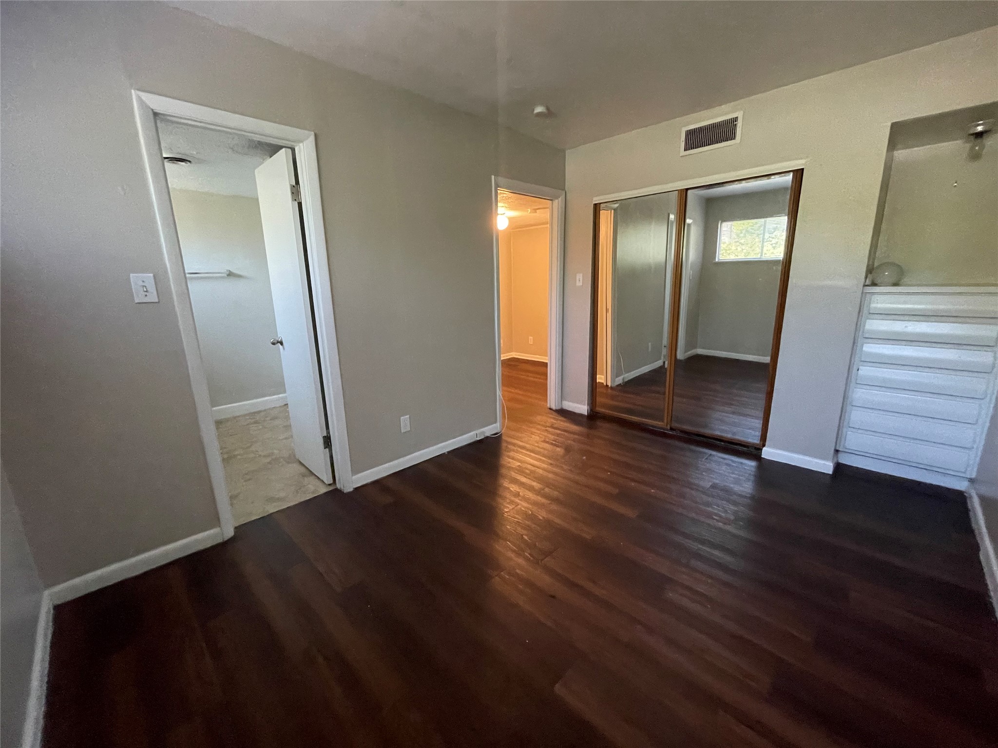 3304 Red River Street, Unit 102 Austin, TX 78705 - Photo 6 of 15 an empty room with wooden floor and mirror