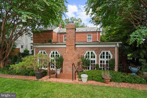 a front view of a house with a garden and plants