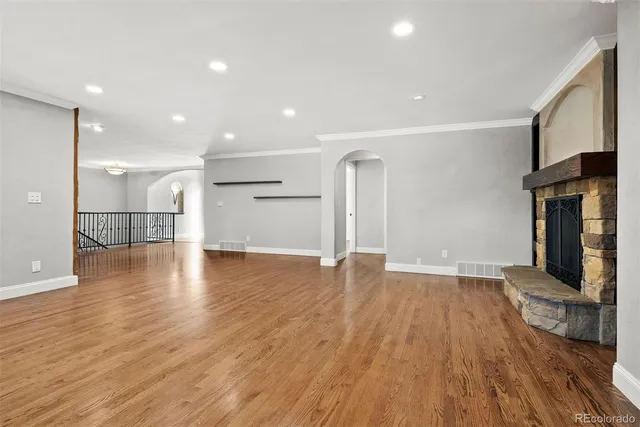 a view of empty room with wooden floor and fireplace