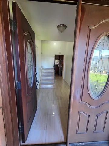 a view of a hallway and wooden floor with entryway