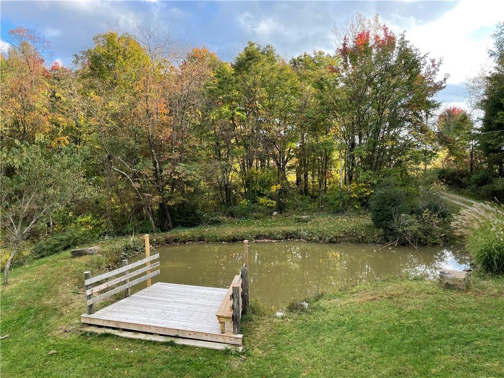 401 Bear Rocks Road Acme, PA 15610 - Photo 3 of 25 a view of a lake with a yard and large trees