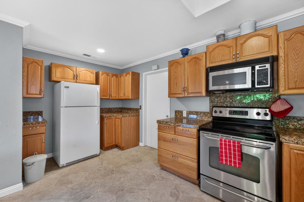 10653 Campana Way Rancho Cordova, CA 95670 - Photo 21 of 49 a kitchen with stainless steel appliances granite countertop a refrigerator and a stove top oven