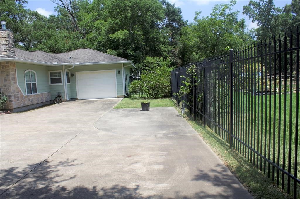 10702 Crosby Lynchburg Road Highlands, TX 77562 - Photo 7 of 18 a view of a house with a small yard plants and a large tree
