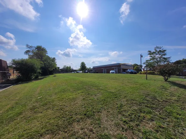 a view of a big yard with a house in the background