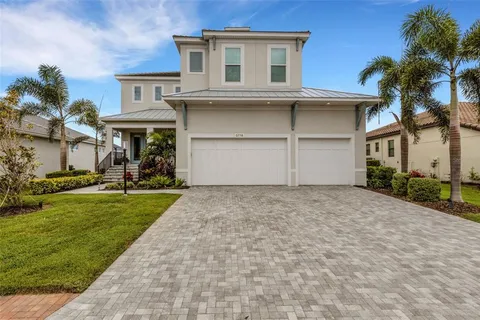 a view of a house with a yard and palm trees