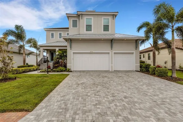 a view of a house with a yard and palm trees
