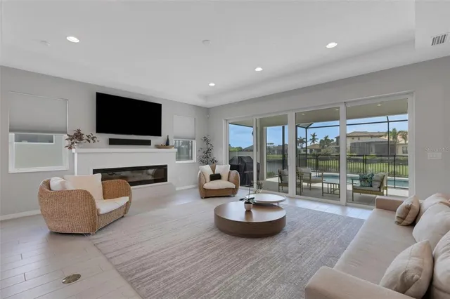 a living room with furniture a flat screen tv and a large window