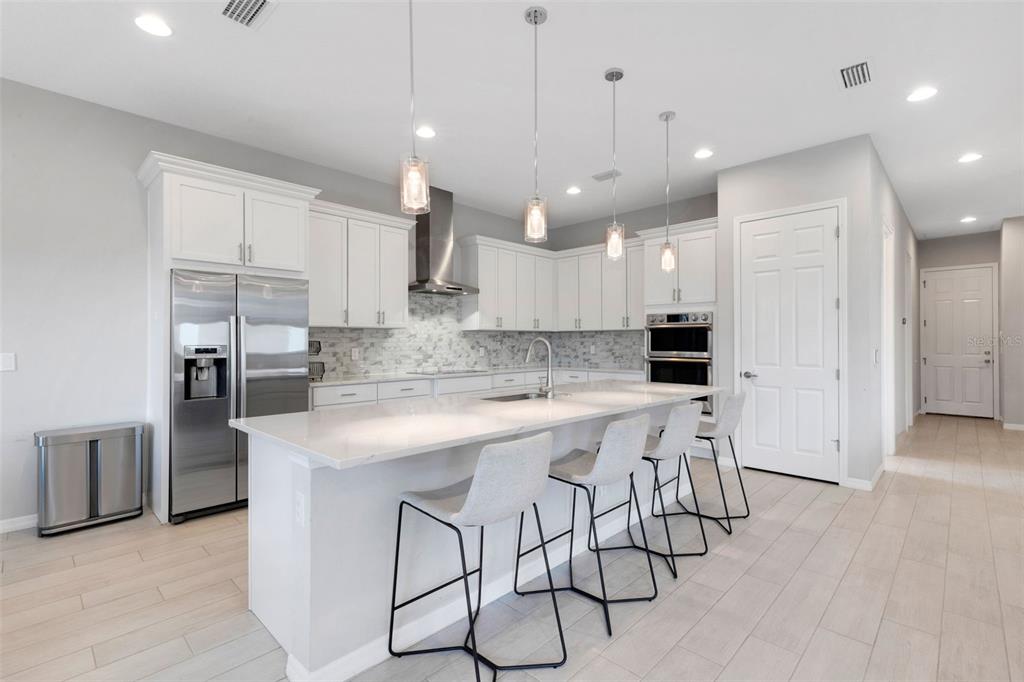 5718 Title Row Drive Bradenton, FL 34210 - Photo 5 of 74 a kitchen with stainless steel appliances kitchen island granite countertop a table chairs sink and cabinets
