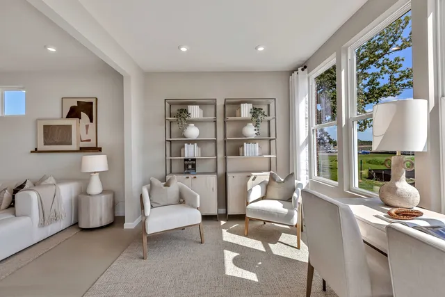 a living room with furniture a lamp and a large window