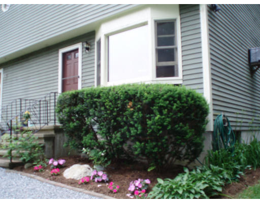 132 Squannacook Road, Unit B Shirley, MA 01464 - Photo 1 of 1 a front view of a house with a yard and flowers