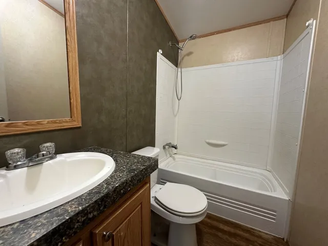 a bathroom with a granite countertop sink toilet and shower