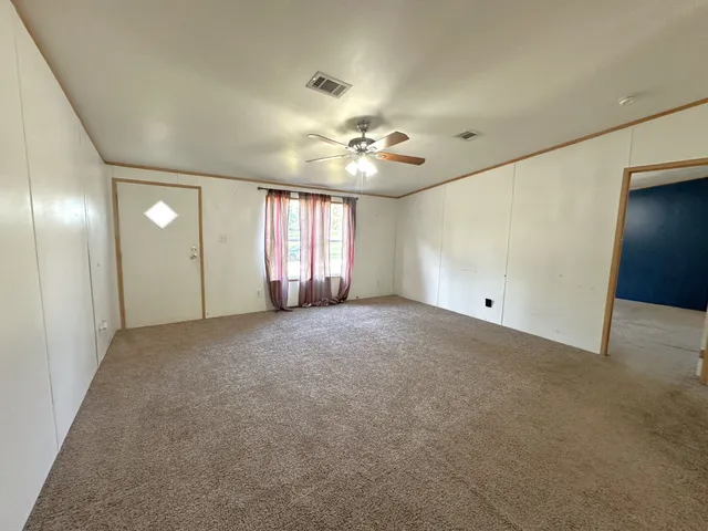 a view of an empty room with a ceiling fan