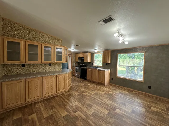 a large kitchen with kitchen island granite countertop a sink window and stainless steel appliances