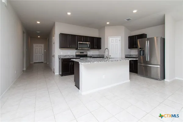 a kitchen with stainless steel appliances granite countertop a refrigerator oven a sink and a microwave