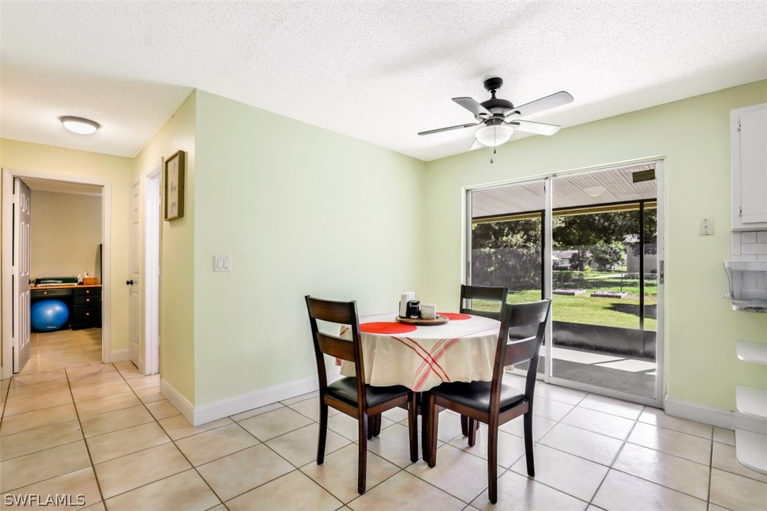 2310 Caladium Road Fort Myers, FL 33905 - Photo 17 of 31 a dining room with furniture and a floor to ceiling window