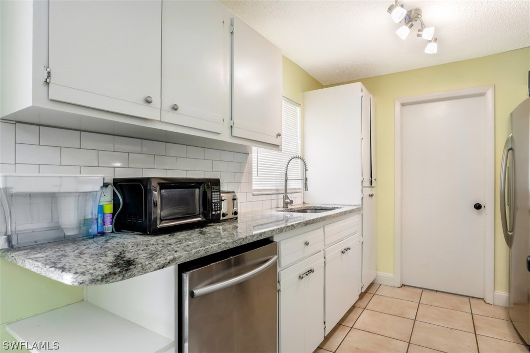 2310 Caladium Road Fort Myers, FL 33905 - Photo 19 of 31 a kitchen with stainless steel appliances granite countertop a sink a stove and cabinets