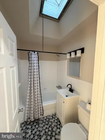 a white toilet sitting next to a bathroom sink and vanity